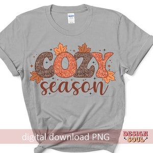 May include: A light gray t-shirt with the words "COZY season" in a fall-themed design. The word "COZY" is in glittery brown and orange letters, with autumn leaves and stars. The text "digital download PNG" is at the bottom.