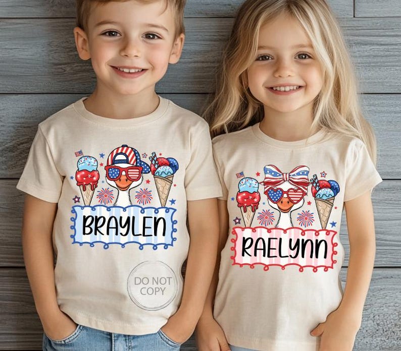 May include: Two children wearing beige t-shirts with patriotic designs. Each shirt features a cartoon duck wearing sunglasses and a hat or bow, with ice cream cones and the names "BRAYLEN" and "RAELYNN" in a decorative frame. The shirts are perfect for Independence Day.