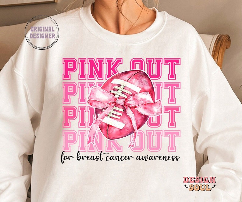 May include: White sweatshirt with a pink football and the text "PINK OUT for breast cancer awareness".