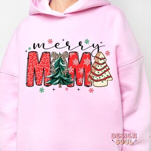 May include: Pink hoodie with a Christmas design that says "merry mama" with a red, green, and white color scheme. The design features a Christmas tree with a bow and snowflakes.