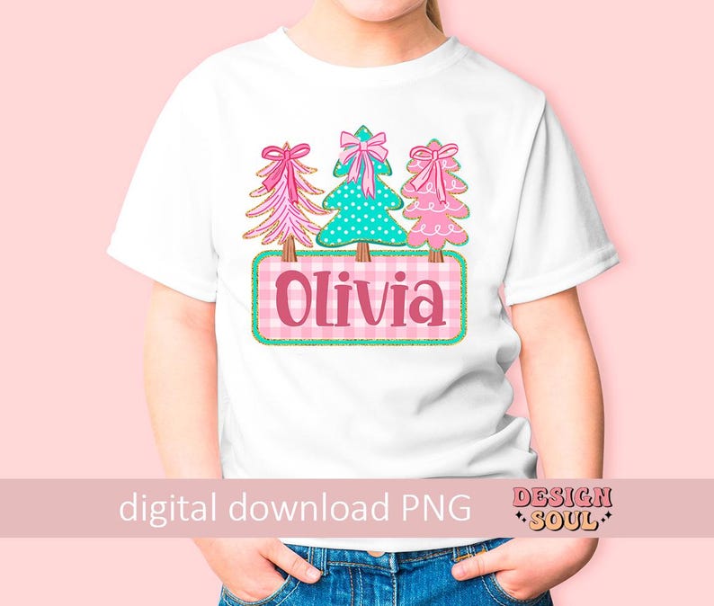 May include: White t-shirt featuring three Christmas trees with bows, a teal polka-dot tree, and a pink gingham nameplate that says "Olivia". The shirt has a pink background and the words "digital download PNG".