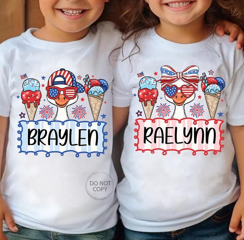 May include: White t-shirts with patriotic designs. One shirt features a goose wearing sunglasses and a hat, with the name "BRAYLEN" below. The other shirt has a goose with a bow and heart-shaped sunglasses, with the name "RAELYNN". Both shirts have ice cream cones and fireworks.