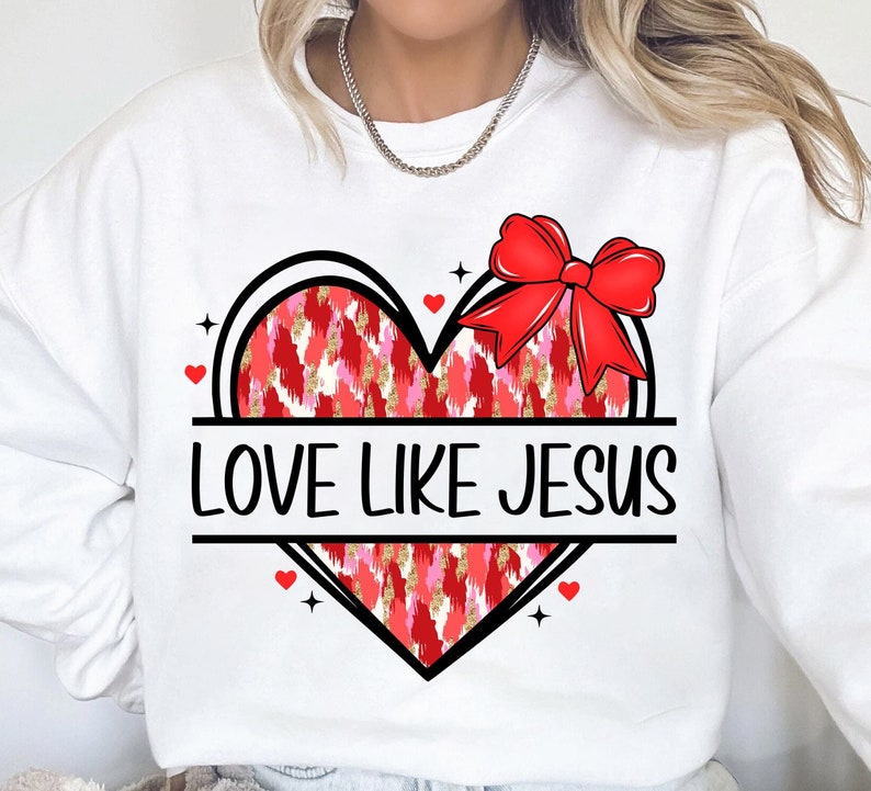 May include: White sweatshirt with a red and pink heart design and the text "LOVE LIKE JESUS".