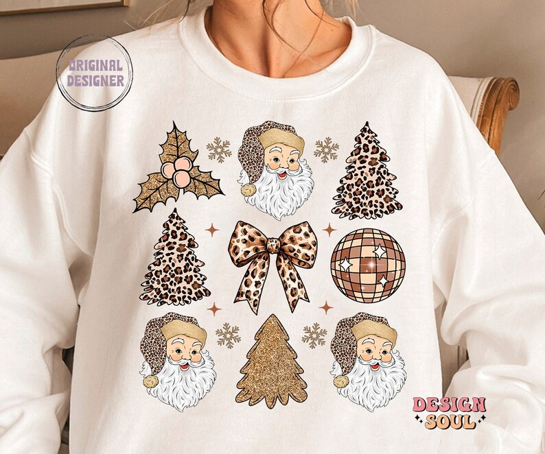 May include: White sweatshirt with a Christmas design featuring Santa Claus, a leopard print Christmas tree, a gold glitter Christmas tree, a disco ball, a bow, and holly. The text "Design Soul" is printed on the bottom right corner of the sweatshirt.