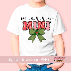 May include: A white t-shirt with a red and pink "Merry Mini" design with a green bow and holly. The shirt is on a child model.