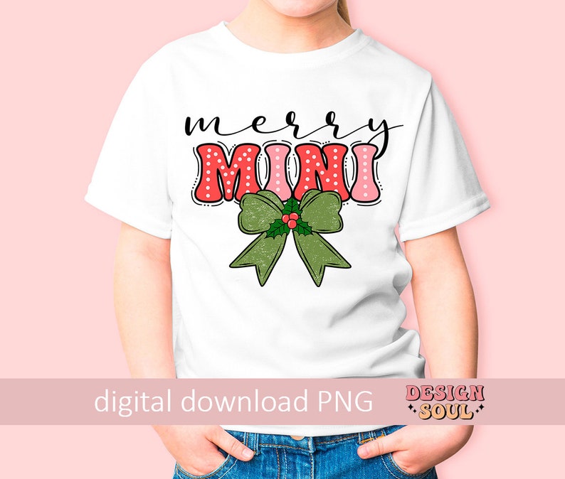 May include: A white t-shirt with a red and pink "Merry Mini" design with a green bow and holly. The shirt is on a child model.