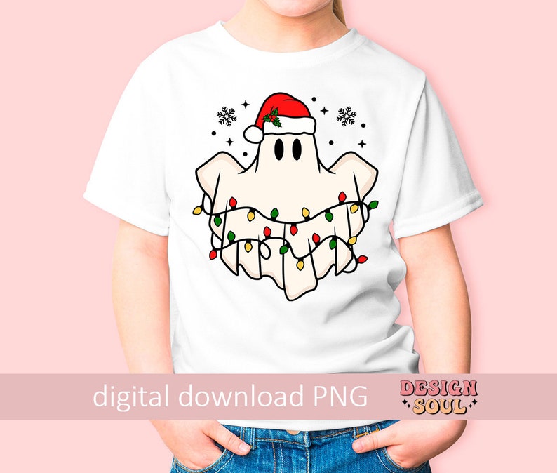 May include: A white t-shirt with a cartoon ghost wearing a Santa hat and Christmas lights. The ghost is white with black eyes and a red Santa hat with green holly. The Christmas lights are red, green, and yellow.