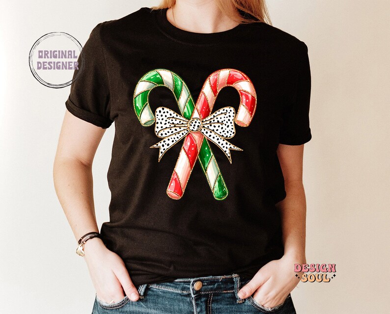 May include: Black t-shirt with a graphic of two red and green candy canes tied together with a white and black polka dot bow.