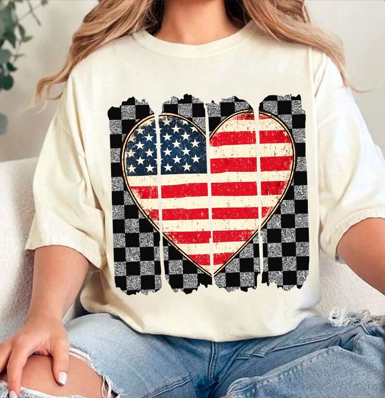 May include: A white t-shirt with a distressed American flag heart design. The heart is surrounded by a black and white checkered pattern.