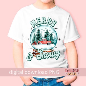 May include: A white t-shirt with a snow globe design featuring a red truck, green trees, and the text "Merry & Snowy".