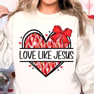 May include: White sweatshirt with a red and pink heart design and the text "LOVE LIKE JESUS".