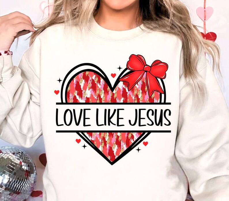 May include: White sweatshirt with a red and pink heart design and the text "LOVE LIKE JESUS".