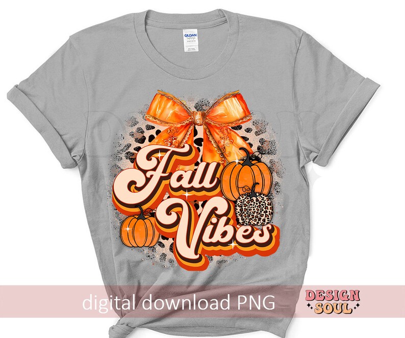 May include: A gray t-shirt with a graphic design featuring a large orange bow, pumpkins, and the text "Fall Vibes" in a retro font.