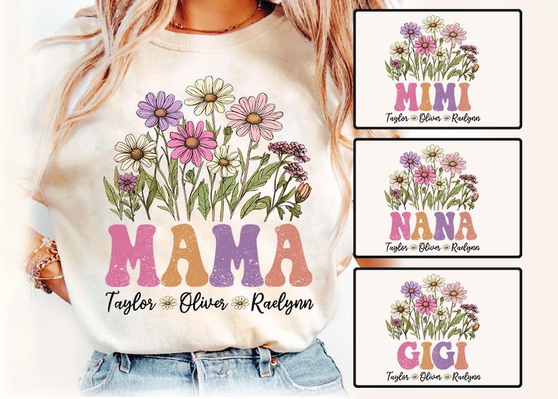 May include: Cream-colored t-shirt featuring a floral design with daisies in shades of purple, pink, and white. The word "MAMA" is printed in retro-style letters. Additional designs include "MIMI", "NANA", and "GIGI" with names below.