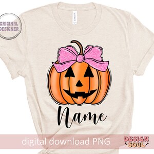 May include: A beige t-shirt with a pumpkin with a pink bow and the word "Name" printed on it. The shirt is a digital download PNG file.
