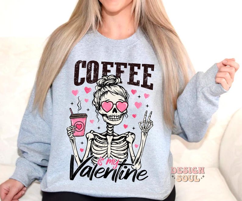 May include: Gray sweatshirt with a skeleton holding a coffee cup and wearing heart-shaped sunglasses. The text on the sweatshirt reads "Coffee is my Valentine".
