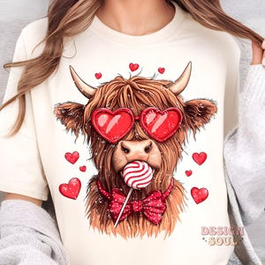May include: A brown Highland cow with red heart-shaped sunglasses and a red bow tie is holding a red and white lollipop. The cow is surrounded by red hearts.