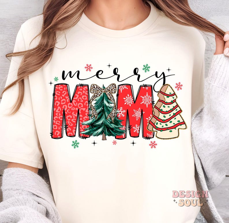 May include: White t-shirt with a red "Merry Mama" design featuring a Christmas tree with a bow, snowflakes, and a gingerbread tree.