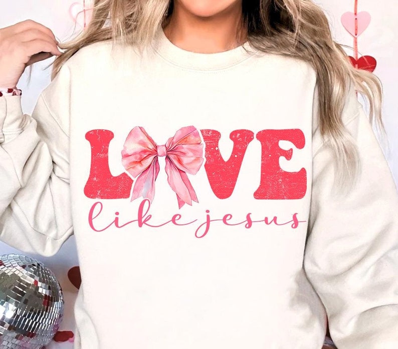 May include: A white sweatshirt with a pink bow and the words "LOVE like jesus" printed on the front.