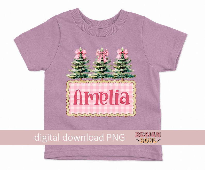 以下が含まれることがあります： ピンクのボウと緑のクリスマスツリー3本がデザインされたパープルのTシャツ。ピンクと白のギンガムチェックの四角形にピンク色の「アメリア」という名前が書かれています。