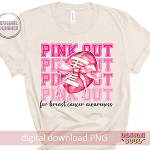 May include: A beige t-shirt with a pink football with a pink ribbon around it. The text "PINK OUT for breast cancer awareness" is printed on the shirt.