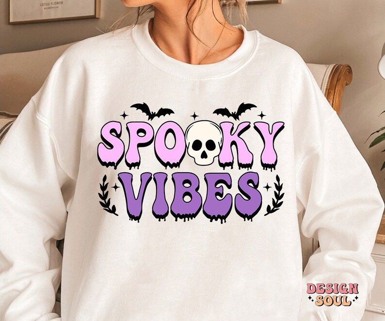 May include: White sweatshirt with a pink and purple graphic that says "Spooky Vibes" with a skull and bats.