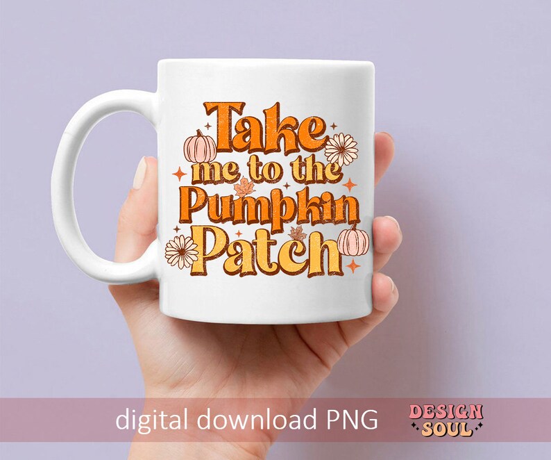 May include: White ceramic mug with a handle. The mug has a graphic design with orange, yellow, and brown colors. The text on the mug reads "Take me to the Pumpkin Patch".