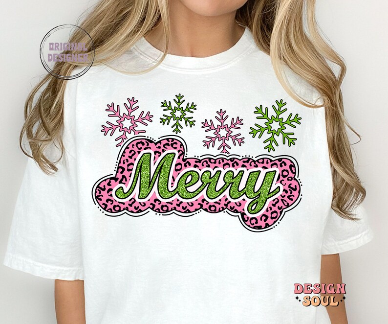 May include: White t-shirt featuring a green and pink "Merry" graphic with a leopard print background. The graphic is surrounded by four pink and green snowflakes.