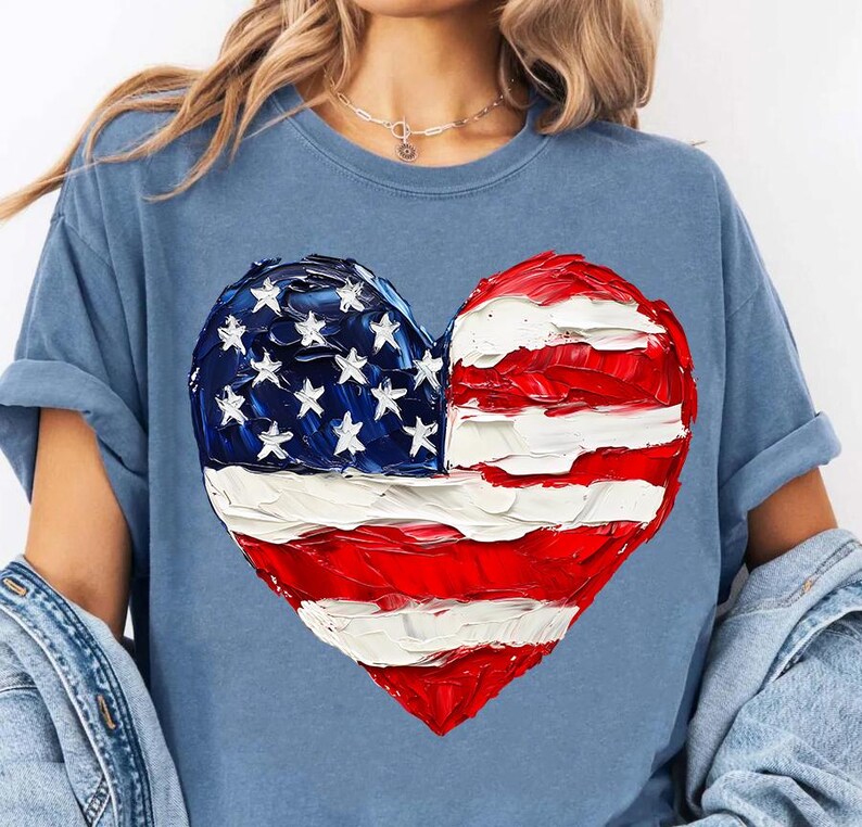 Pu&ograve; includere: Una maglietta blu con una bandiera americana dipinta a forma di cuore.