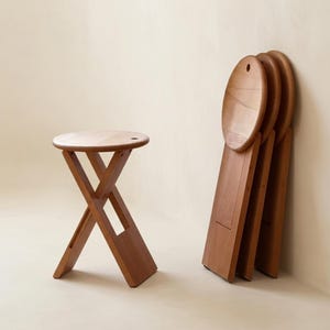 Taburete plegable minimalista: asiento de madera apilable para espacios pequeños.
