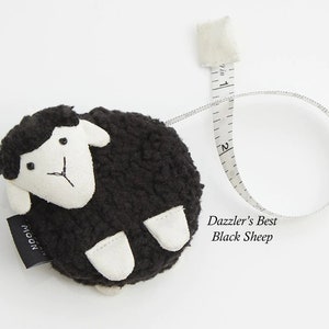 May include: A black sheep-shaped measuring tape with a white face and feet. The tape extends to 2 inches and is labeled "Dazzler's Best Black Sheep". The tape measure is a novelty item.