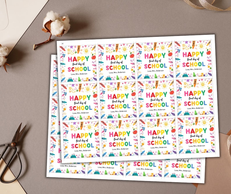 May include: Sheets of colorful "Happy First Day of School" stickers. Each sticker features text, an apple, a pencil, and other school-themed graphics. The stickers are printed on white paper.