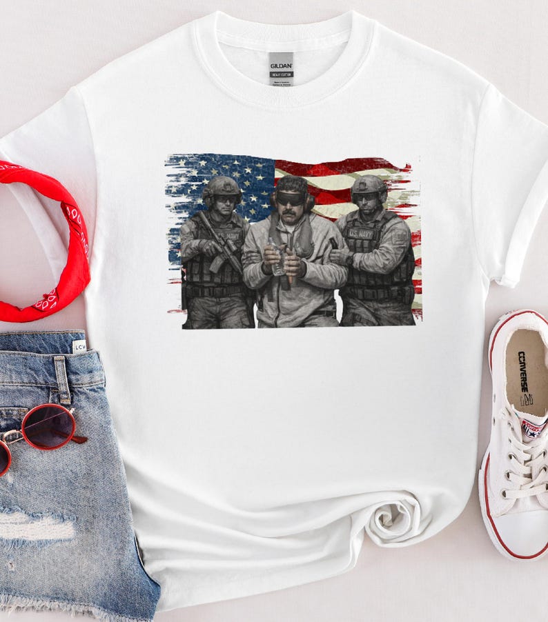 Pode incluir: Camiseta branca com um gr&aacute;fico de tr&ecirc;s soldados em frente a uma bandeira americana desgastada. Os soldados usam equipamento militar. A camisa tem gola redonda e mangas curtas. A marca "GILDAN" &eacute; vis&iacute;vel na etiqueta.