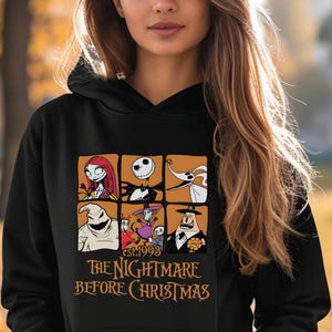 May include: Black hoodie featuring a graphic of characters from "The Nightmare Before Christmas." The design includes images of Sally, Jack Skellington, Zero, Oogie Boogie, and others. The text "est.1993" and "THE NIGHTMARE BEFORE CHRISTMAS" are also displayed.