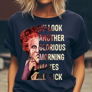 May include: Navy blue t-shirt featuring a graphic of a character with red hair and the text "Oh look another glorious morning makes me sick". The design is a humorous reference to a popular movie.
