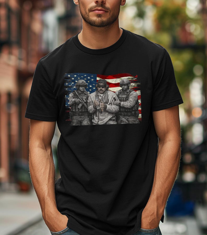 Pode incluir: T-shirt preto com um gr&aacute;fico de tr&ecirc;s soldados em uniforme militar, contra um fundo da bandeira americana. A imagem &eacute; uma ilustra&ccedil;&atilde;o detalhada com uma est&eacute;tica vintage e desgastada.