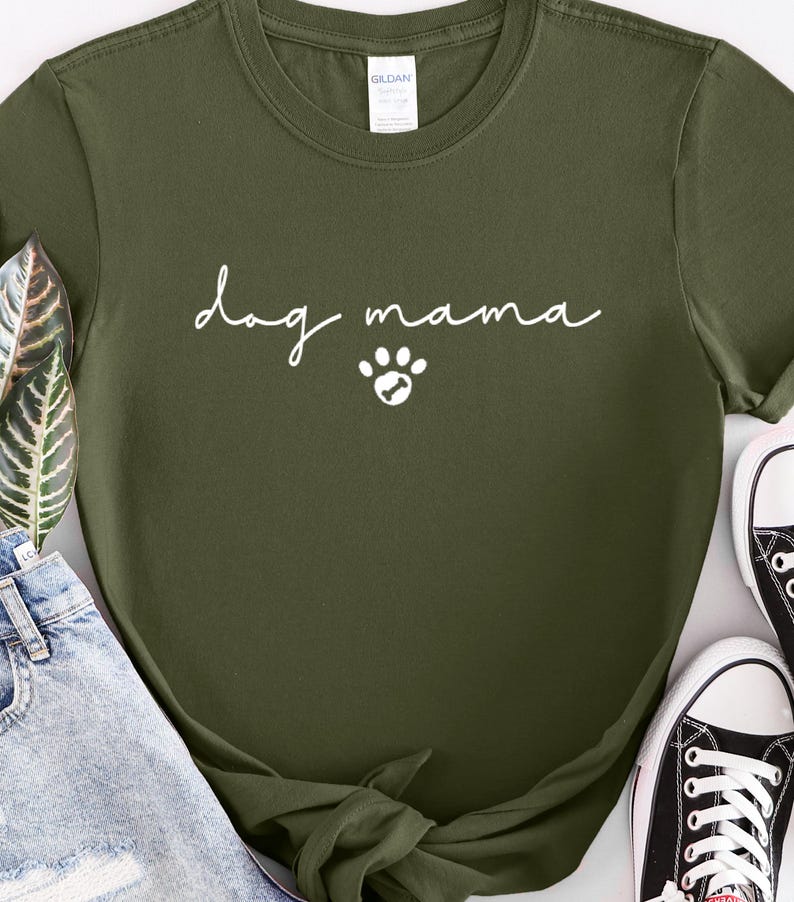 K&ouml;nnte beinhalten: Ein gr&uuml;nes T-Shirt mit dem Text "dog mama" in wei&szlig;en Buchstaben und einem wei&szlig;en Pfotenabdruck.