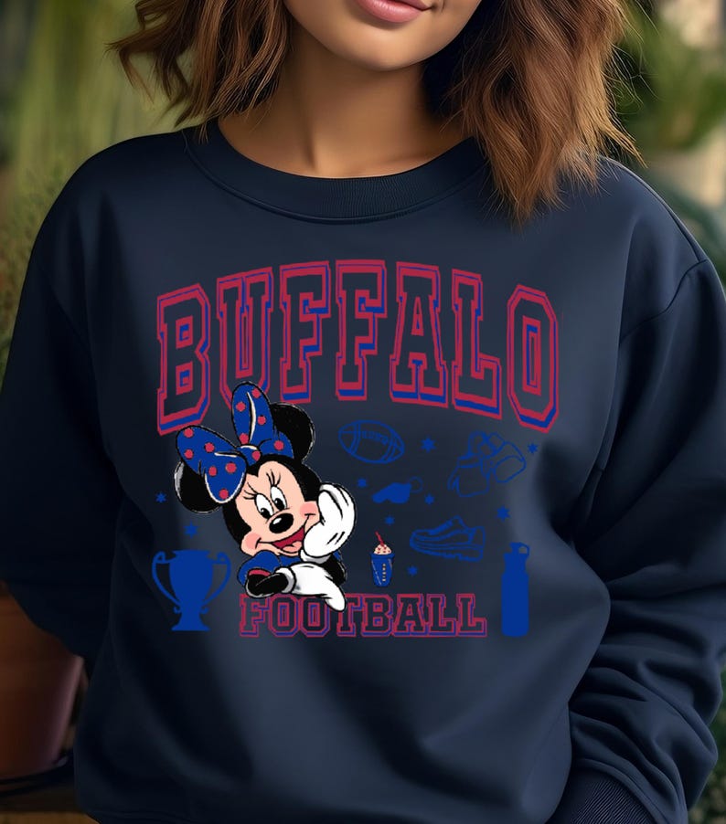 K&ouml;nnte beinhalten: Marineblaues Sweatshirt mit dem Text "BUFFALO FOOTBALL" in Rot und Blau. Minnie Mouse mit einer blauen Schleife mit Punkten ist abgebildet. Football-Grafiken sind ebenfalls zu sehen.