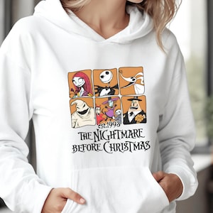 May include: White hooded sweatshirt featuring a graphic of characters from "The Nightmare Before Christmas." The design includes a grid of character portraits and the text "est.1993 THE NIGHTMARE BEFORE CHRISTMAS" in black.