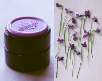 Gracing the Dawn Solid Natural Perfume in Round Jar, abundant with an ethereal fresh violet, floral bouquet made with essential oils