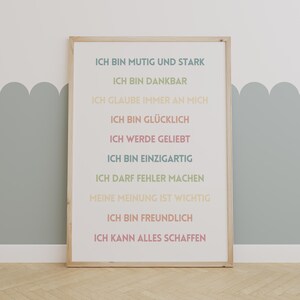 Könnte beinhalten: Ein gerahmter Druck mit weißem Hintergrund und einer Reihe positiver Affirmationen auf Deutsch. Der Text lautet: "Ich bin mutig und stark", "Ich bin dankbar", "Ich glaube immer an mich", "Ich bin glücklich", "Ich werde geliebt", "Ich bin einzigartig", "Ich darf Fehler machen", "Meine Meinung ist wichtig", "Ich bin freundlich", "Ich kann alles schaffen".