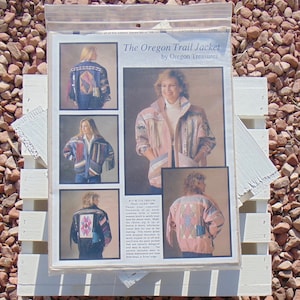 May include: A sewing pattern for a jacket called "The Oregon Trail Jacket" by Oregon Treasures. The pattern includes instructions and a variety of patchwork designs. The pattern is available in sizes from Small to Extra Large.