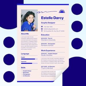 May include: A graphic design resume template featuring a photo of a woman in a blue top. The resume is for Estelle Darcy, a Graphic Designer, and includes contact details, education, and work history. The design is light pink with blue accents.