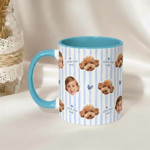 May include: A ceramic mug with a blue handle and interior. The mug features a vertical striped pattern in white and light blue. Adorning the mug are images of a child's face, a poodle, and the text "I LOVE YOU DAD".