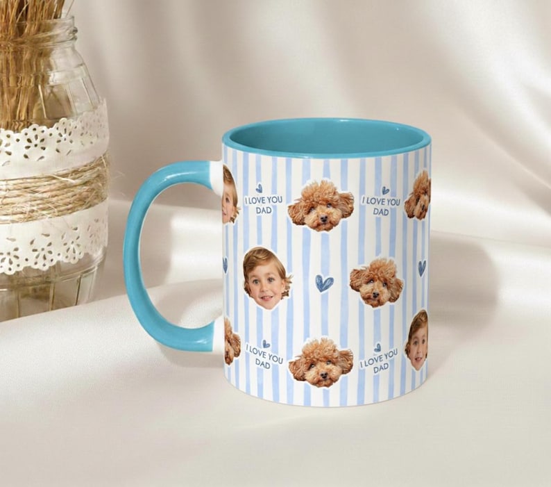 May include: A ceramic mug with a blue handle and interior. The mug features a vertical striped pattern in white and light blue. Adorning the mug are images of a child's face, a poodle, and the text "I LOVE YOU DAD".