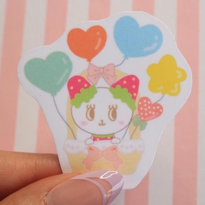 Sticker en vinyle Charmant chat aux fraises sur un ballon de rêve, sticker pop art rose avec breloque kawaii et détails du ruban, en forme de coeur, en forme d'étoile