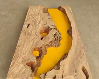 May include: A rectangular wooden table with a vibrant yellow resin river running through the center. The wood has a natural, light brown color with visible grain and knots. The table measures approximately 30 inches long.