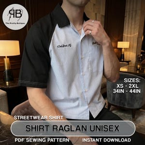 May include: A unisex raglan shirt with black sleeves and a light blue and white striped body. The shirt has a button-down front and a collar. Text on the shirt reads "42nd Street NY". Sizes available: XS - 2XL, 34 - 44 inches.