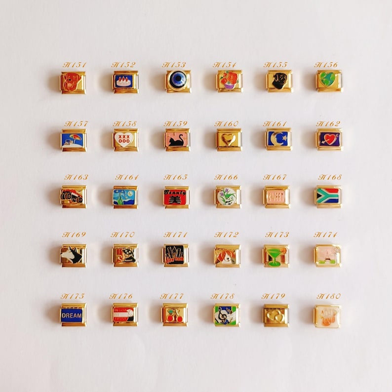 Puede incluir: Una colecci&oacute;n de treinta eslabones modulares dorados para pulsera, dispuestos en cinco filas de seis. Cada eslab&oacute;n rectangular presenta un dise&ntilde;o &uacute;nico en esmalte de colores, incluyendo animales, s&iacute;mbolos, banderas y la palabra DREAM, etiquetados del H151 al H180.