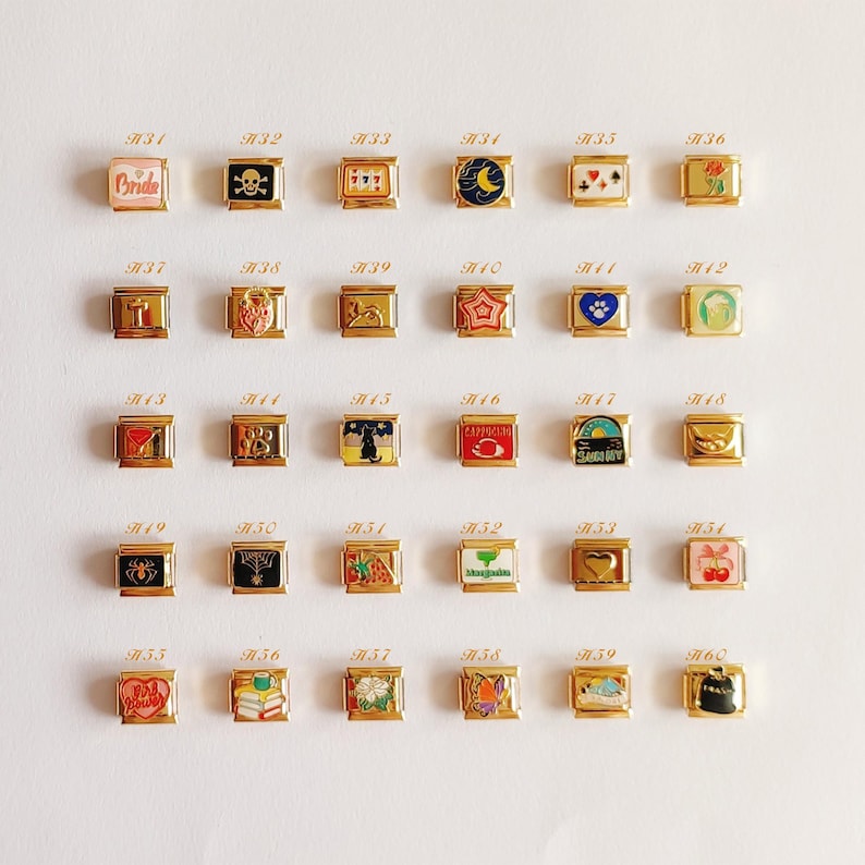 Puede incluir: Una colecci&oacute;n de treinta eslabones modulares dorados para pulsera, dispuestos en cinco filas de seis. Cada eslab&oacute;n cuadrado presenta un dise&ntilde;o &uacute;nico en esmalte de colores, incluyendo s&iacute;mbolos como una calavera, coraz&oacute;n, estrella, gato, cereza.